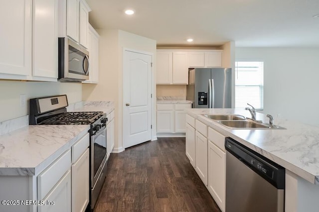 kitchen with dark wood finished floors, stainless steel appliances, white cabinetry, a sink, and recessed lighting