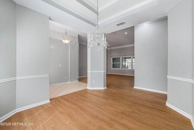 unfurnished dining area featuring a notable chandelier, wood finished floors, visible vents, baseboards, and crown molding