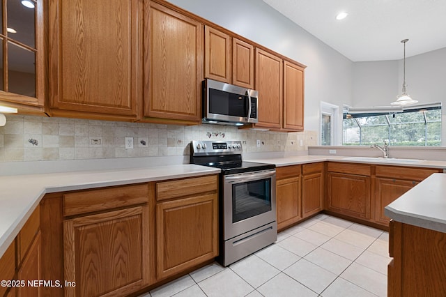 kitchen featuring light tile patterned floors, tasteful backsplash, appliances with stainless steel finishes, brown cabinets, and a sink