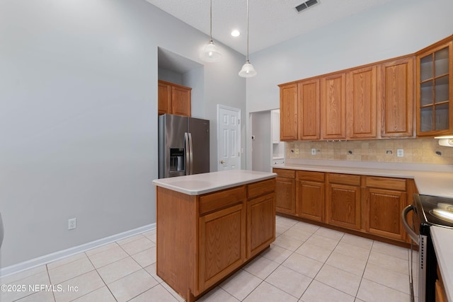 kitchen featuring light tile patterned floors, stainless steel appliances, visible vents, and decorative backsplash