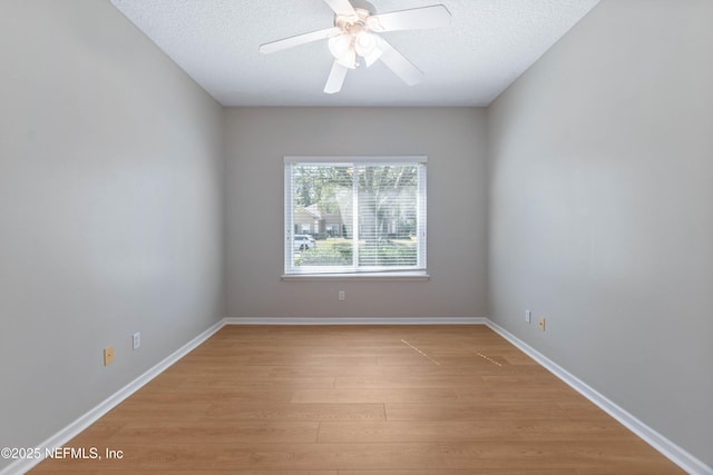 unfurnished room featuring a textured ceiling, ceiling fan, light wood-style flooring, and baseboards