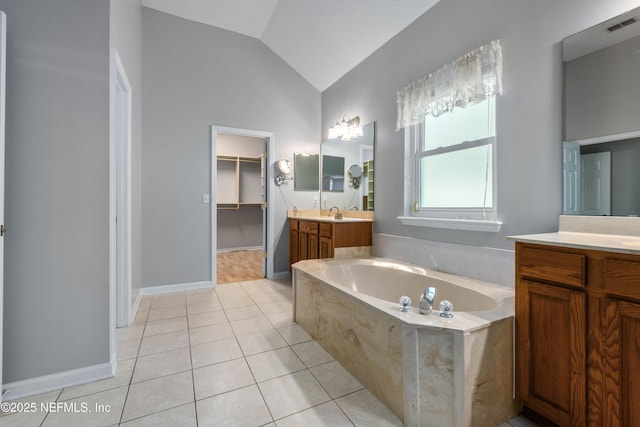 bathroom with a garden tub, two vanities, visible vents, vaulted ceiling, and tile patterned flooring