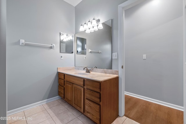 bathroom with vanity, baseboards, and tile patterned floors