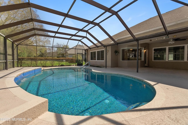 outdoor pool with a patio area, glass enclosure, and a ceiling fan