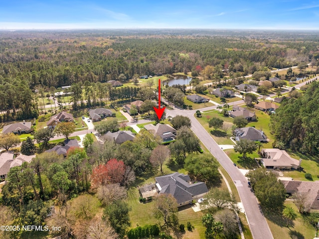 birds eye view of property featuring a forest view, a water view, and a residential view