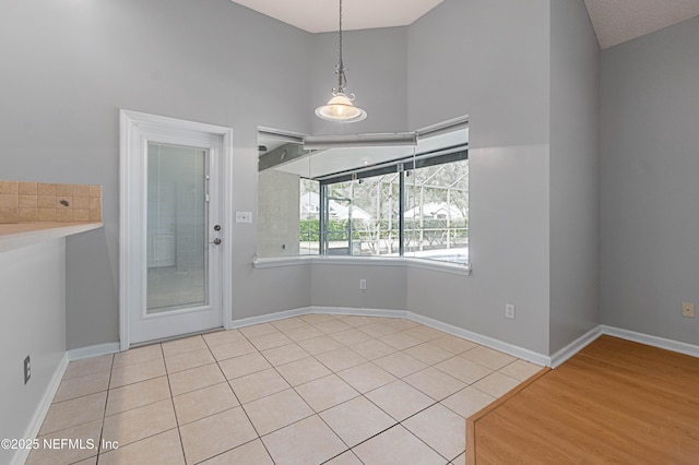 unfurnished dining area featuring tile patterned flooring and baseboards