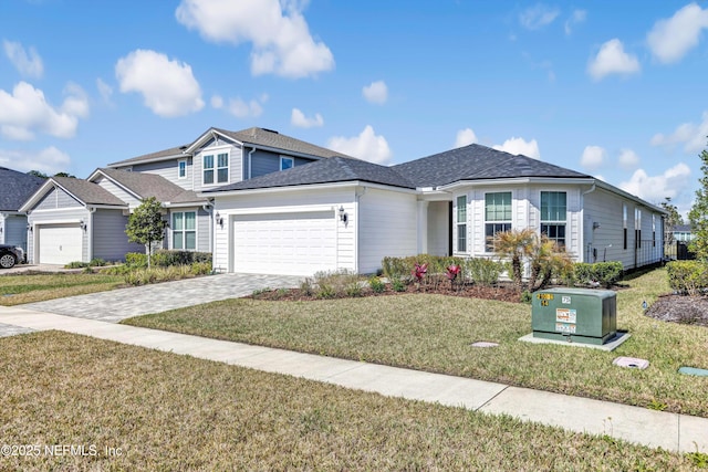 view of front facade featuring an attached garage, decorative driveway, and a front yard