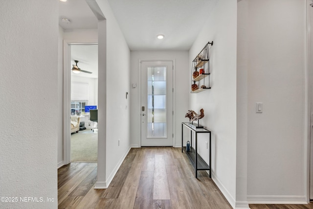 doorway with light wood-style floors and baseboards