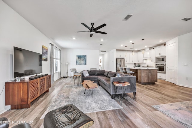 living area with visible vents and light wood-style flooring