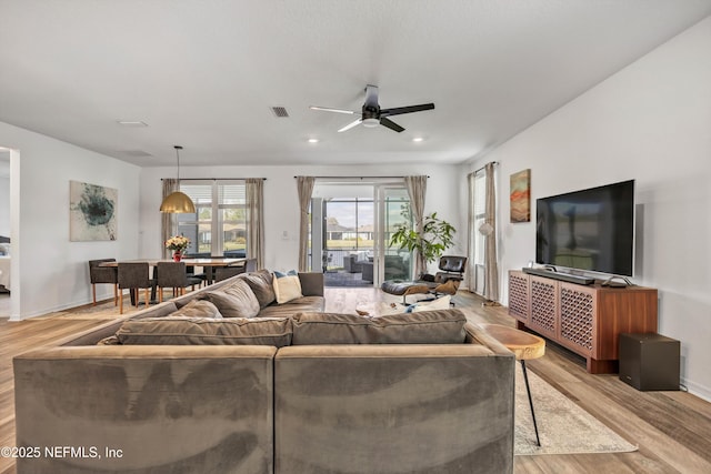 living area featuring ceiling fan, recessed lighting, visible vents, baseboards, and light wood-style floors