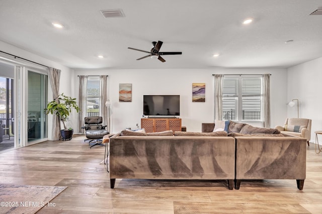 living room featuring light wood-style flooring, recessed lighting, visible vents, and a ceiling fan