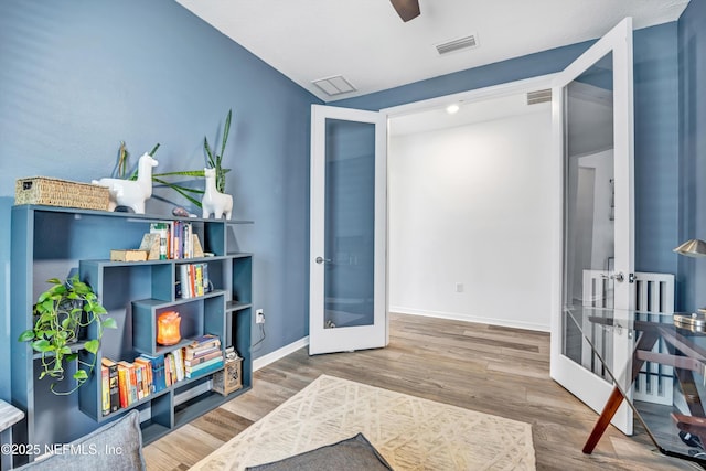 sitting room featuring french doors, wood finished floors, visible vents, and baseboards