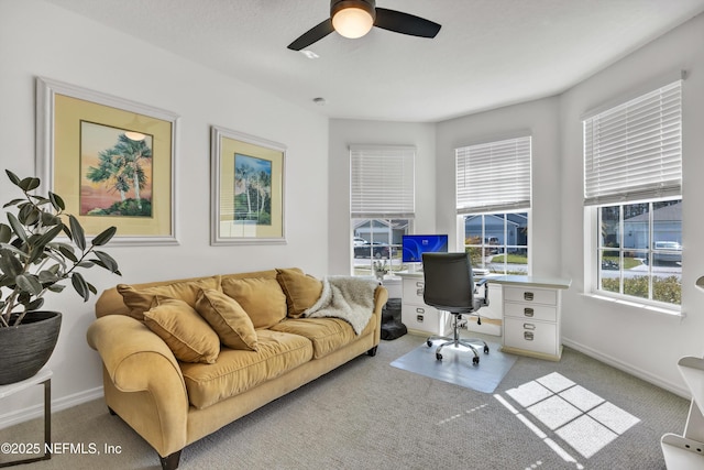 office area with ceiling fan, baseboards, and light colored carpet