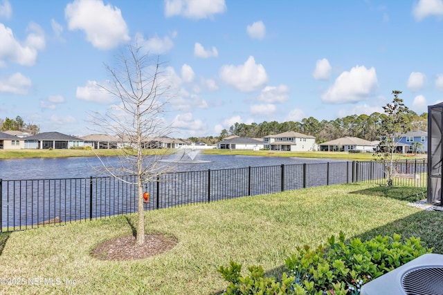 view of yard featuring a water view, a residential view, and fence