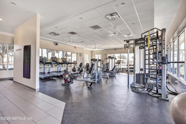 exercise room featuring a drop ceiling, visible vents, and baseboards