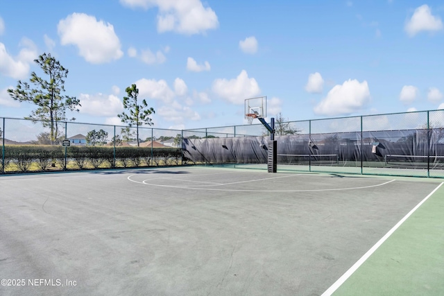 view of sport court featuring a tennis court, community basketball court, and fence