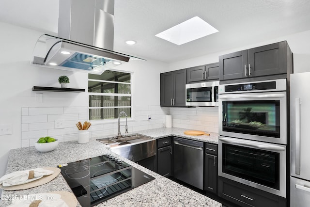 kitchen featuring stainless steel appliances, light stone countertops, island range hood, and open shelves