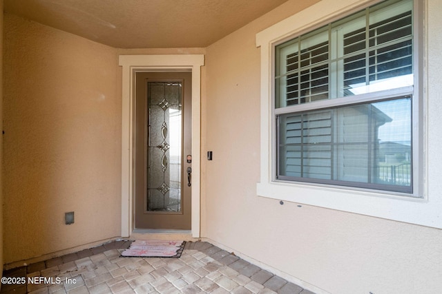 view of exterior entry featuring stucco siding