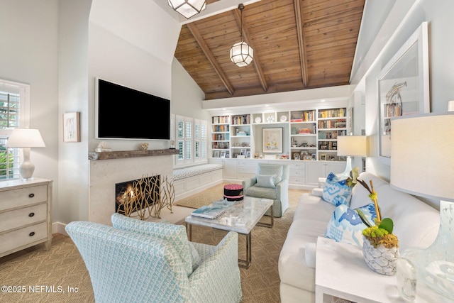 living area featuring wood ceiling, high vaulted ceiling, beam ceiling, and a lit fireplace