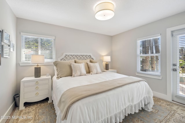 bedroom featuring access to outside and baseboards