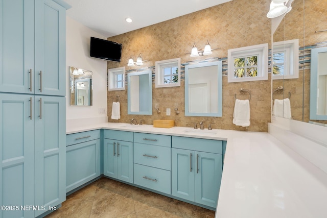 full bath featuring tiled shower, a sink, decorative backsplash, and double vanity