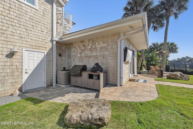 view of patio with a grill, fence, and central AC unit