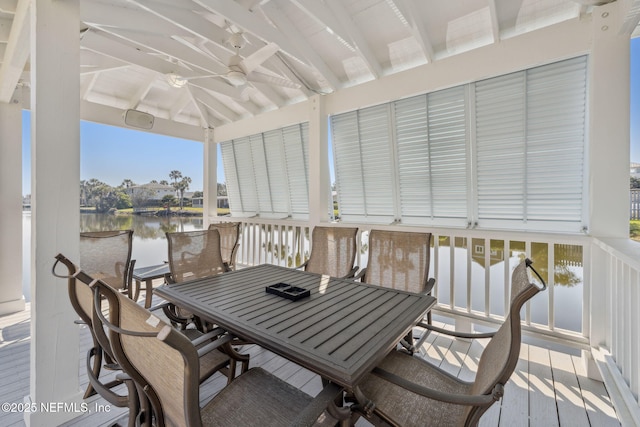 sunroom / solarium featuring vaulted ceiling with beams and a water view