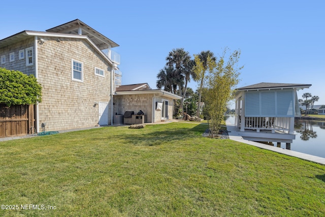 view of yard with a water view, fence, and central AC unit