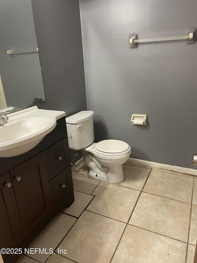 bathroom with baseboards, vanity, toilet, and tile patterned floors