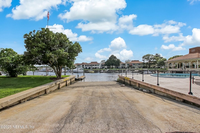 dock area with a water view and a community pool