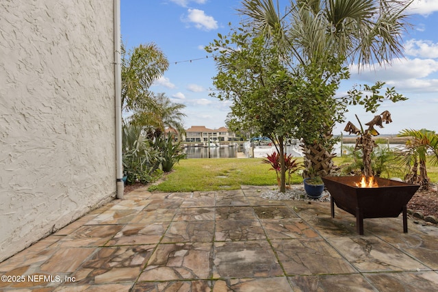 view of patio / terrace with a water view and a fire pit