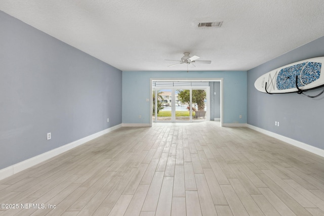 unfurnished living room with light wood-type flooring, baseboards, visible vents, and ceiling fan