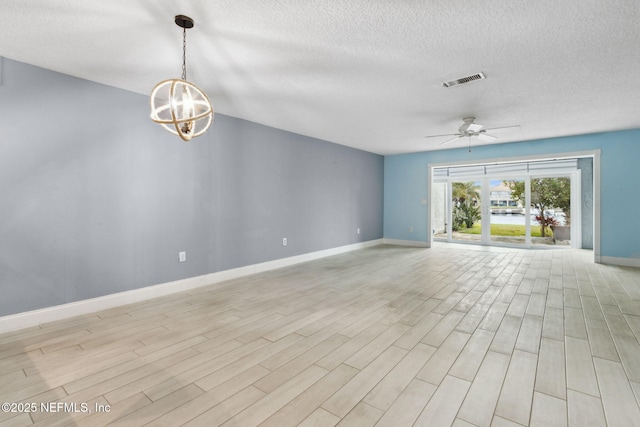 unfurnished living room featuring visible vents, a textured ceiling, light wood-type flooring, baseboards, and ceiling fan with notable chandelier