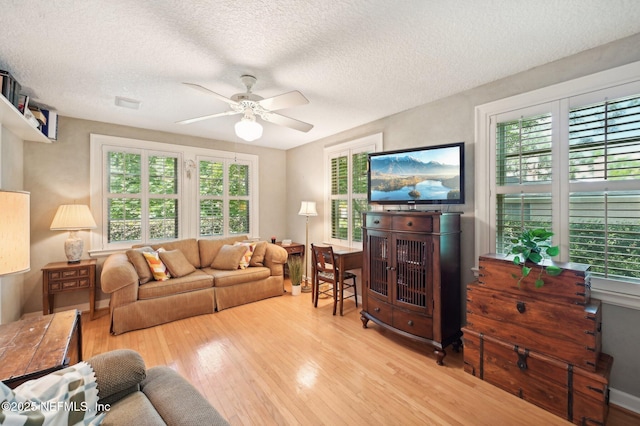 living room featuring a textured ceiling, a ceiling fan, and wood finished floors