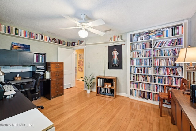 office with ceiling fan, a textured ceiling, visible vents, and wood finished floors