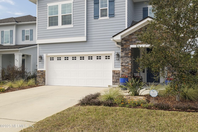 view of front facade with a garage, stone siding, and driveway