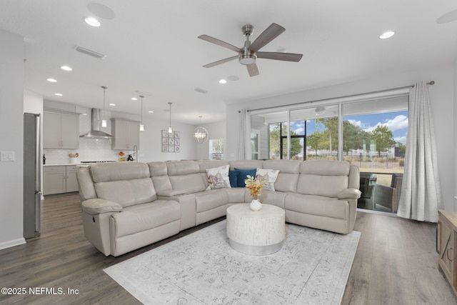 living room with visible vents, wood finished floors, and recessed lighting