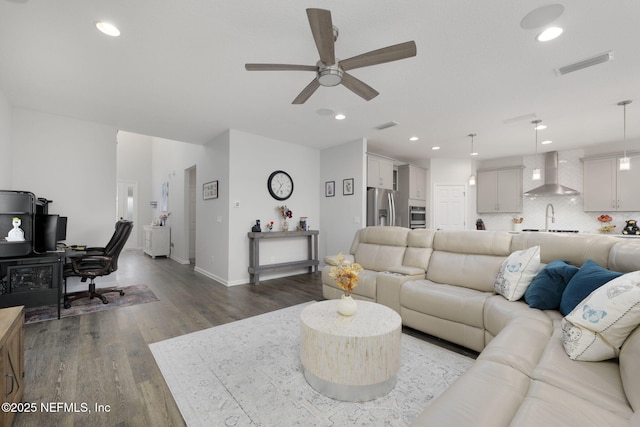 living area featuring recessed lighting, visible vents, a ceiling fan, wood finished floors, and baseboards