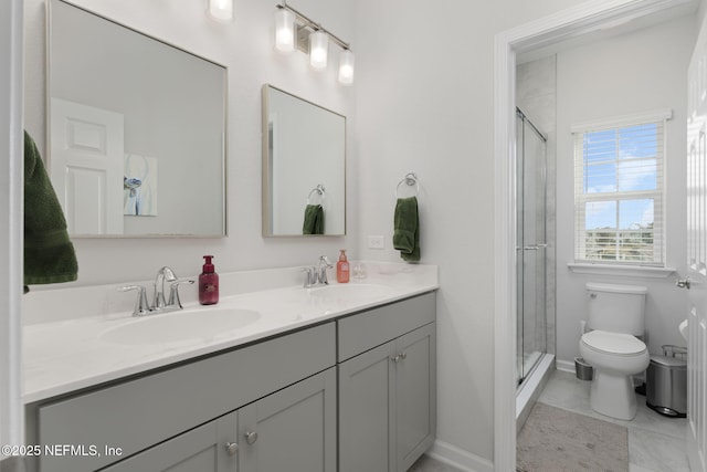 bathroom featuring toilet, a shower stall, and a sink