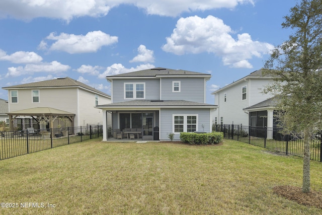 back of house featuring a sunroom, a fenced backyard, a yard, and a gazebo