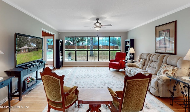 living room featuring ceiling fan, a textured ceiling, light wood-type flooring, and ornamental molding