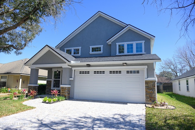 view of front of property featuring stucco siding, stone siding, an attached garage, and decorative driveway