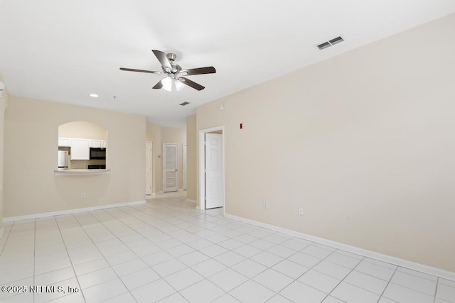 spare room with visible vents, ceiling fan, baseboards, and light tile patterned floors