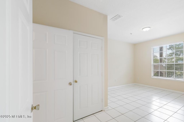 unfurnished bedroom featuring visible vents, baseboards, and light tile patterned floors