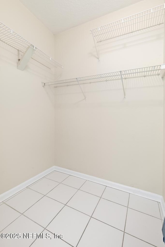 spacious closet with tile patterned floors