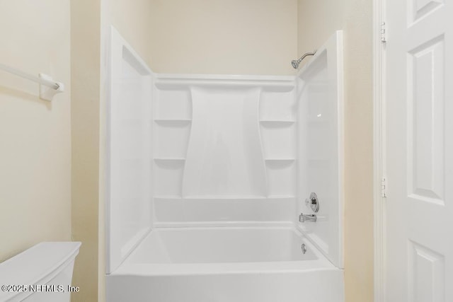 bathroom with shower / bathtub combination and toilet