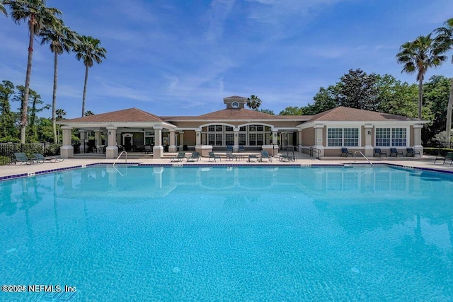 community pool featuring a patio area and fence