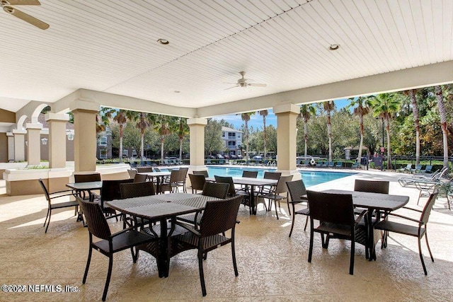 view of patio with ceiling fan, a community pool, and outdoor dining area