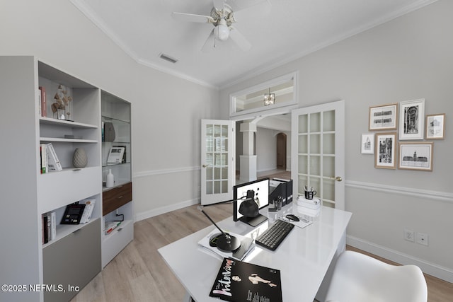 home office featuring arched walkways, crown molding, visible vents, light wood-style floors, and a ceiling fan