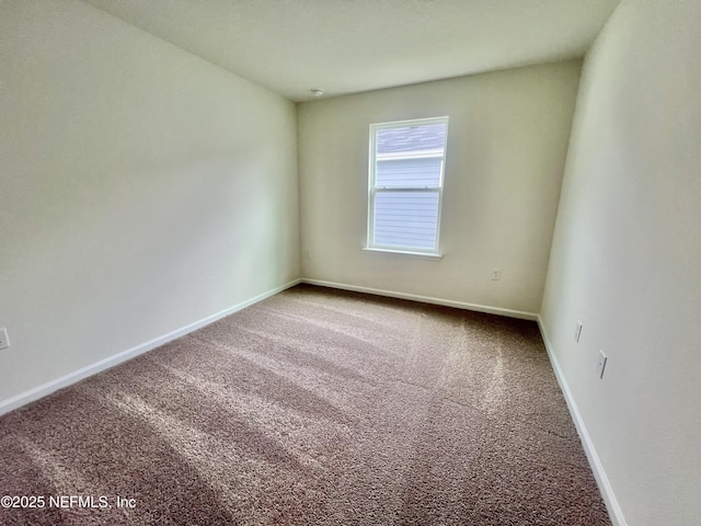 empty room featuring carpet floors and baseboards